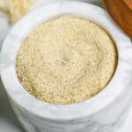 A marble container with all purpose seasoning inside.