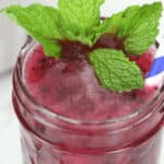 A mason jar of blueberry moonshine.